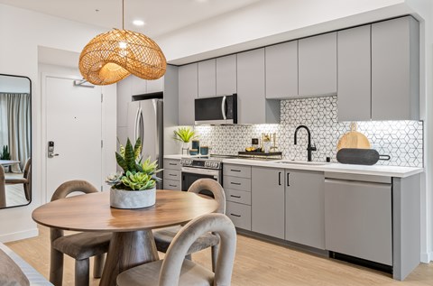 A modern kitchen with a wooden table and chairs.