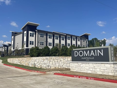 A building with the sign "DOMAIN" in front of it.