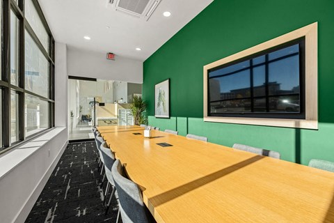 a conference room with green walls and a long table with chairs