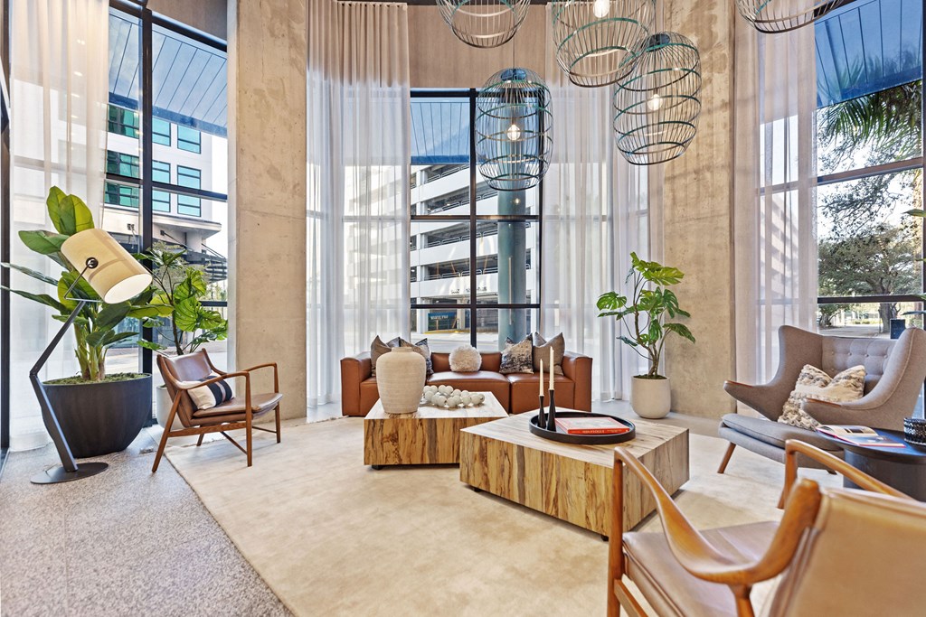 A living room with a large window and a view of a building outside.