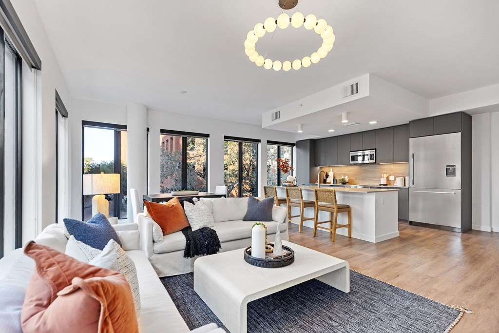 A modern living room with a white sofa and a large window.