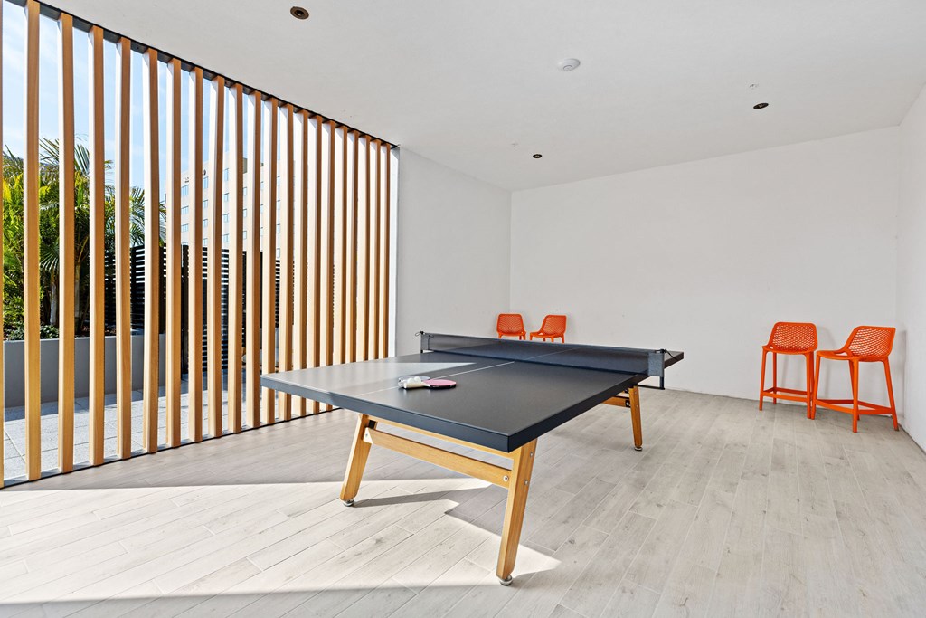 A pool table is in the middle of a room with a sliding door.