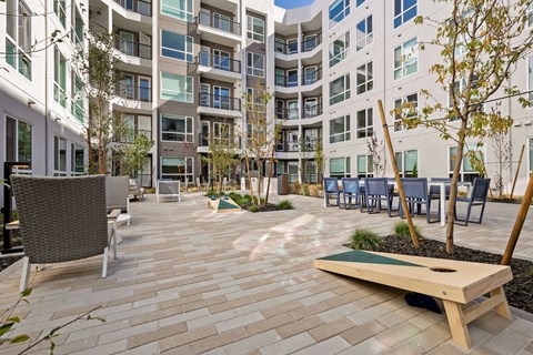 an outdoor patio area with tables and chairs at an apartment building