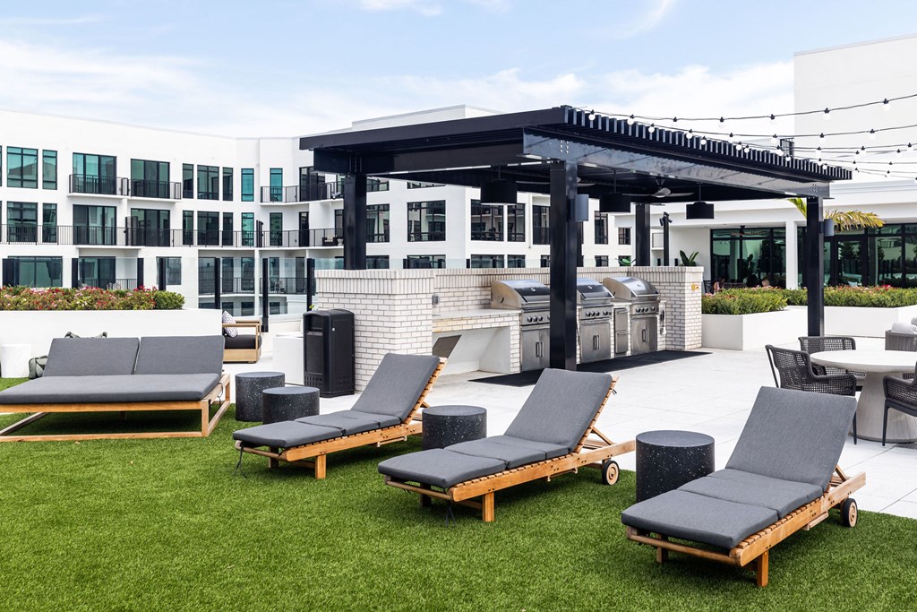 A set of lounge chairs are arranged on a lawn in front of a building.