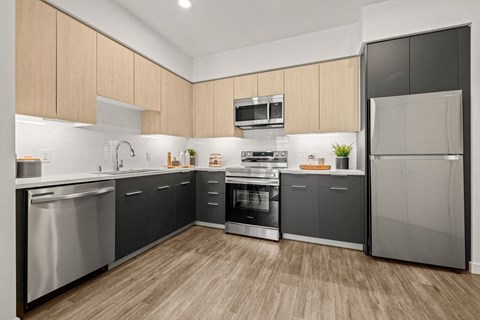 a kitchen with stainless steel appliances and wooden floors