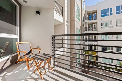 a balcony with a chair and a railing and some buildings