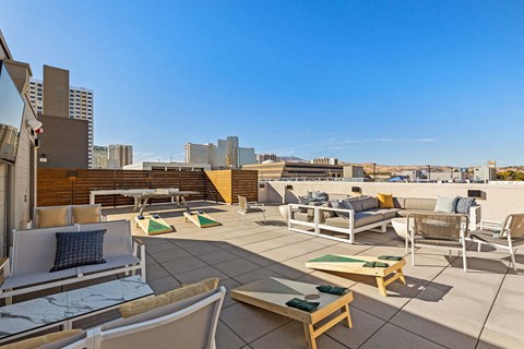 a rooftop terrace with furniture and a view of the city