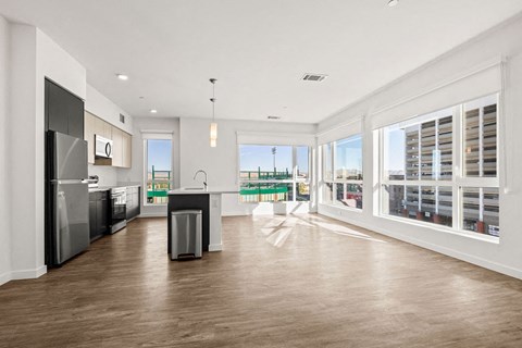 a living room with a kitchen and a large window