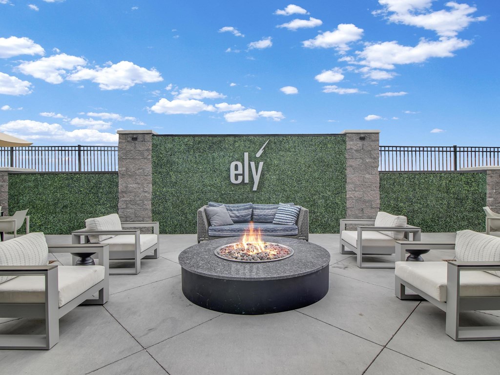 an outdoor patio with a fire pit and chairs