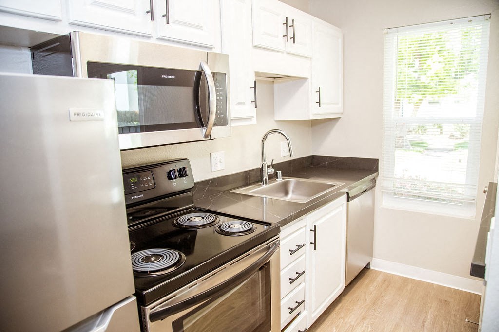a kitchen with stainless steel appliances and white cabinets