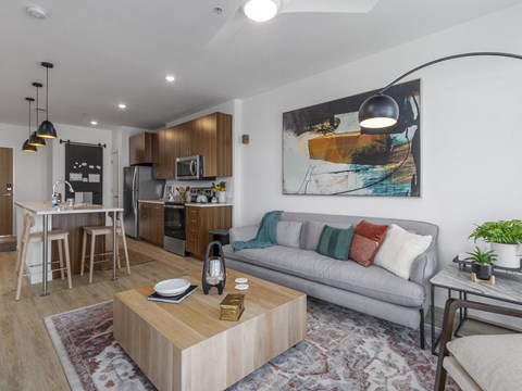 A modern living room with a grey couch and a wooden coffee table.