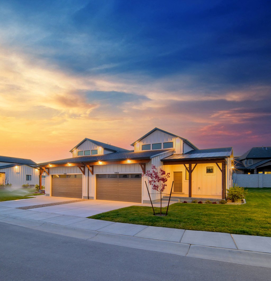 a house at sunset with the sun setting in the background
