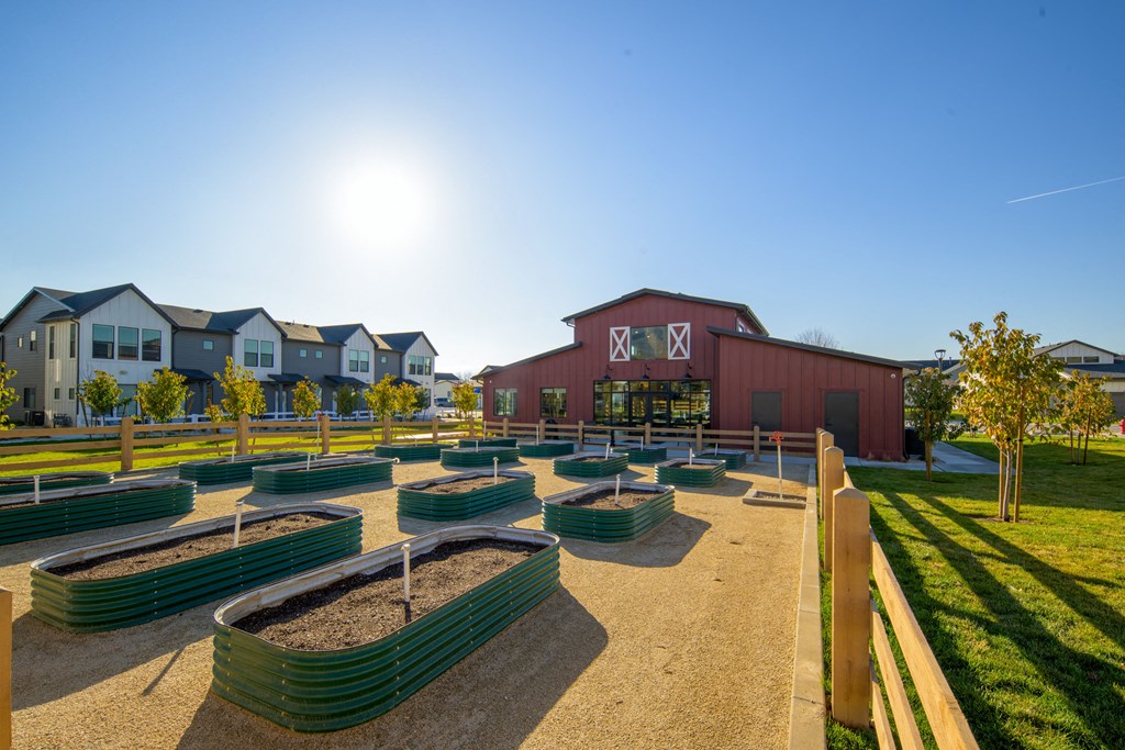 a park with benches and a barn with houses in the background
