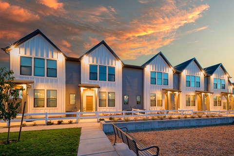 A row of houses with a bench in front of them.