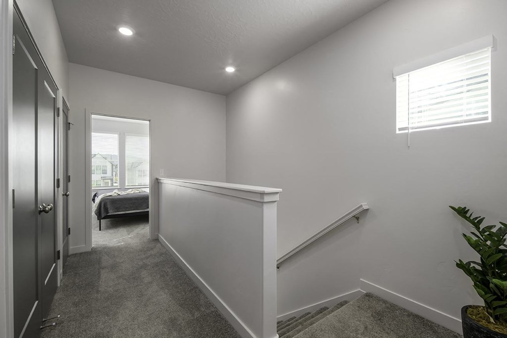 a white room with a hallway and a door to a bedroom