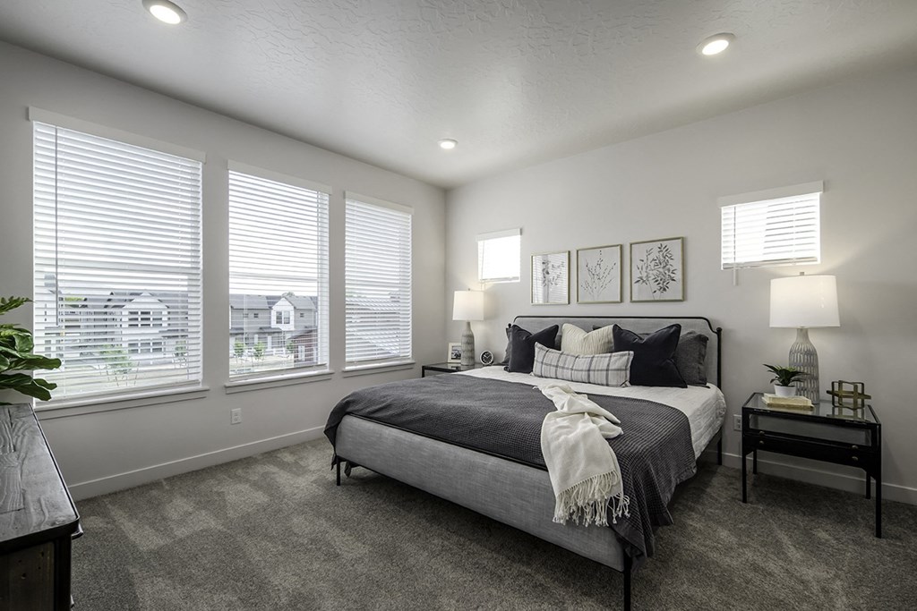 a bedroom with a bed and three windows