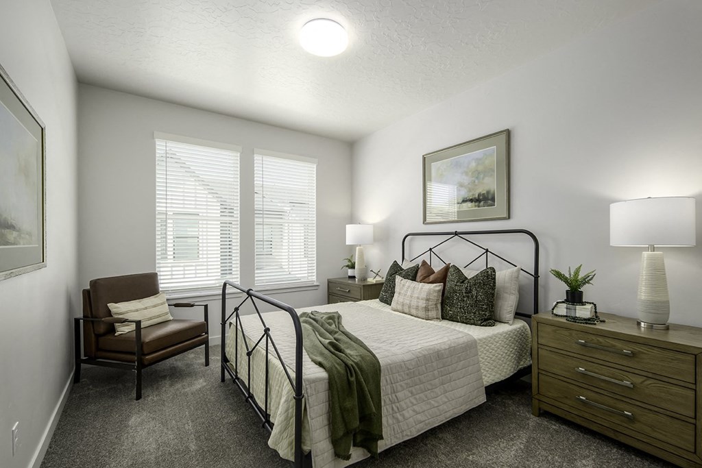 a bedroom with a bed and a chair and a window