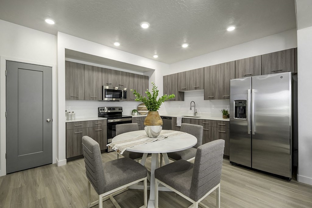a kitchen with stainless steel appliances and a table with chairs