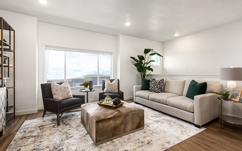 A living room with a brown leather chair, a white couch, and a coffee table with a tray on it.