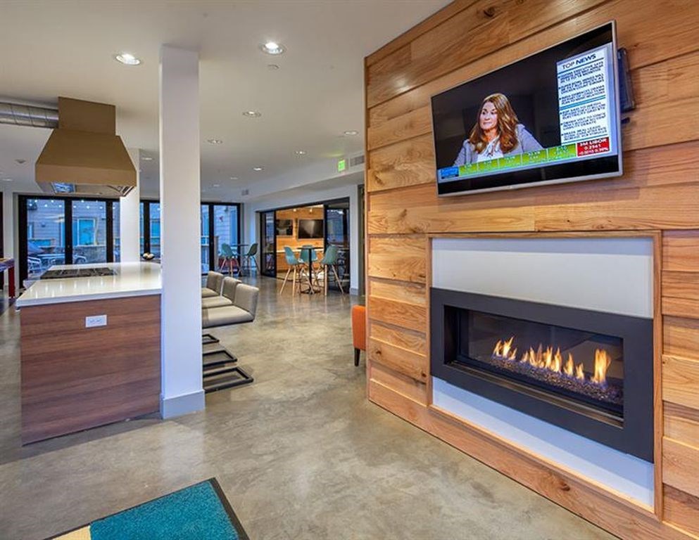 A modern living room with a fireplace and a flat screen TV mounted on the wall.