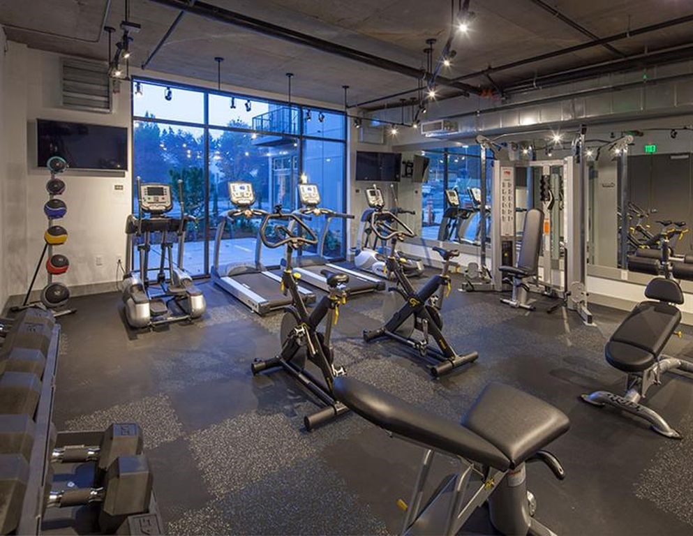 A gym with a variety of equipment including treadmills, weights, and exercise machines.