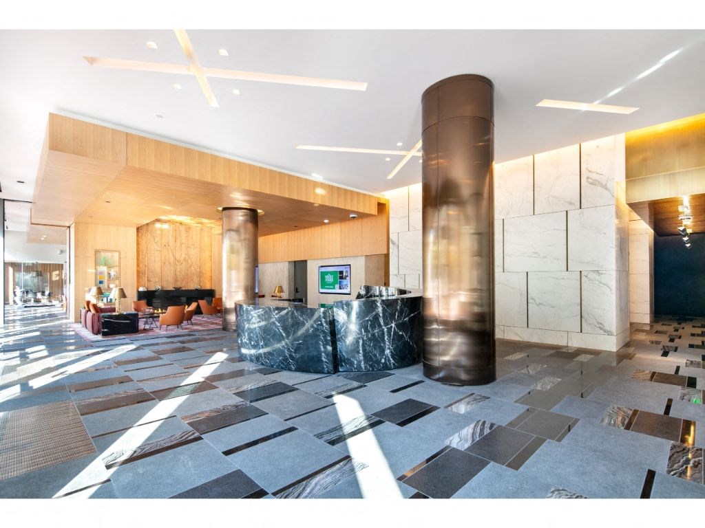 a large lobby with marble pillars and a large screen on the wall