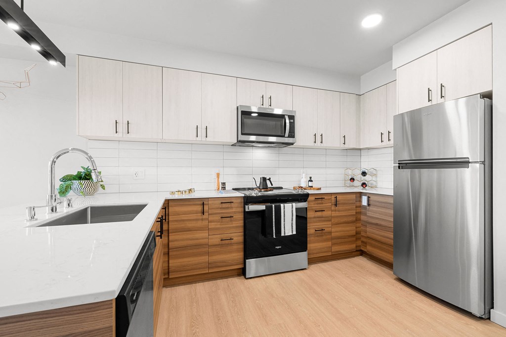 a kitchen with white countertops and wooden cabinets at Ion Town Center, Shoreline, WA