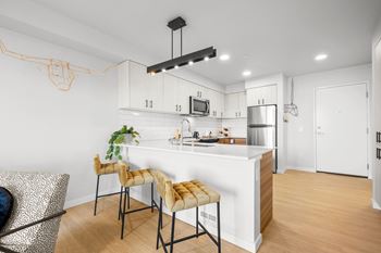 a kitchen with white cabinets and a large island with a white countertopat Ion Town Center, Washington, 98133