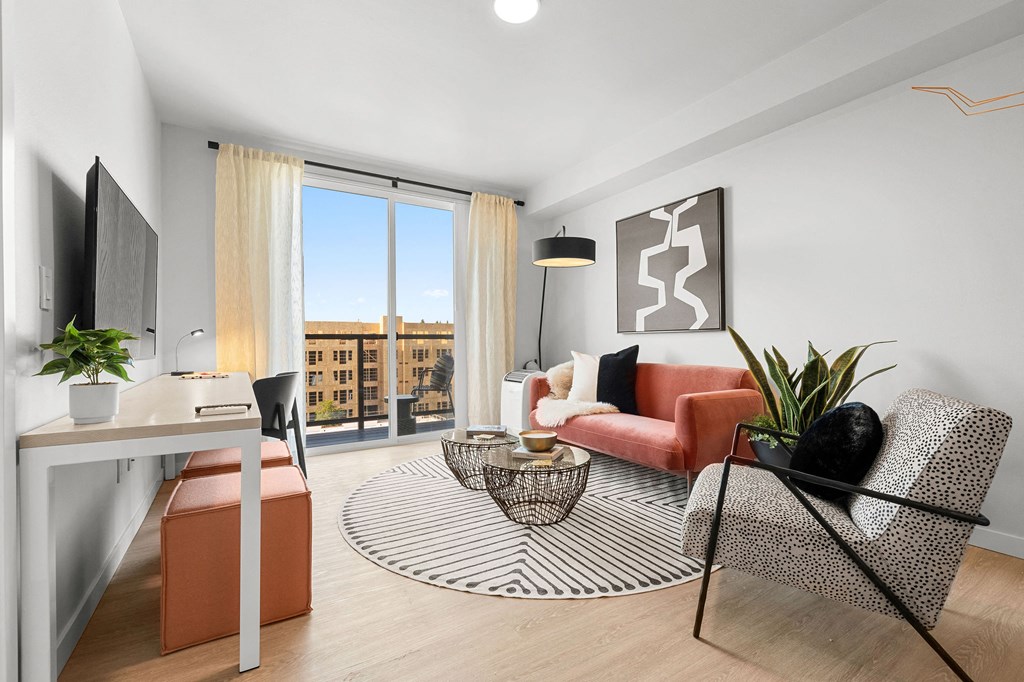 a living room with white walls and hardwood floors and a sliding glass door that leads to at Ion Town Center, Shoreline, WA