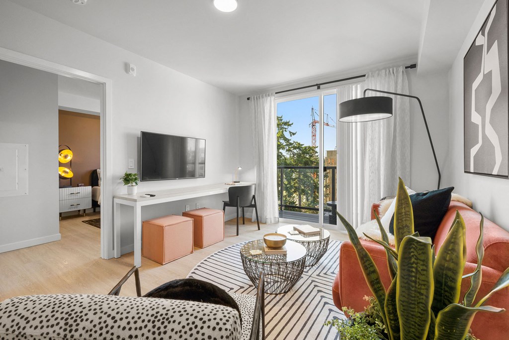 a living room with white walls and a sliding glass door that leads to a balcony at Ion Town Center, Shoreline