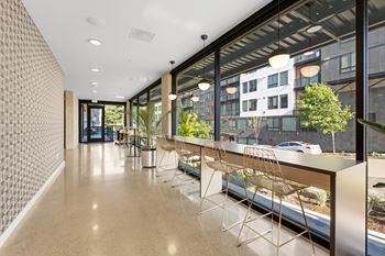 a long corridor with a long counter and a row of chairs in front of a large window at Ion Town Center, Shoreline, 98133