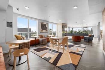 a seating area with tables and chairs at the enclave at woodbridge apartments in sugar land at Ion Town Center, Shoreline, WA