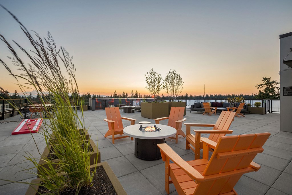 a patio with a firepit and chairs on a roof  at Ion Town Center, Shoreline Washington
