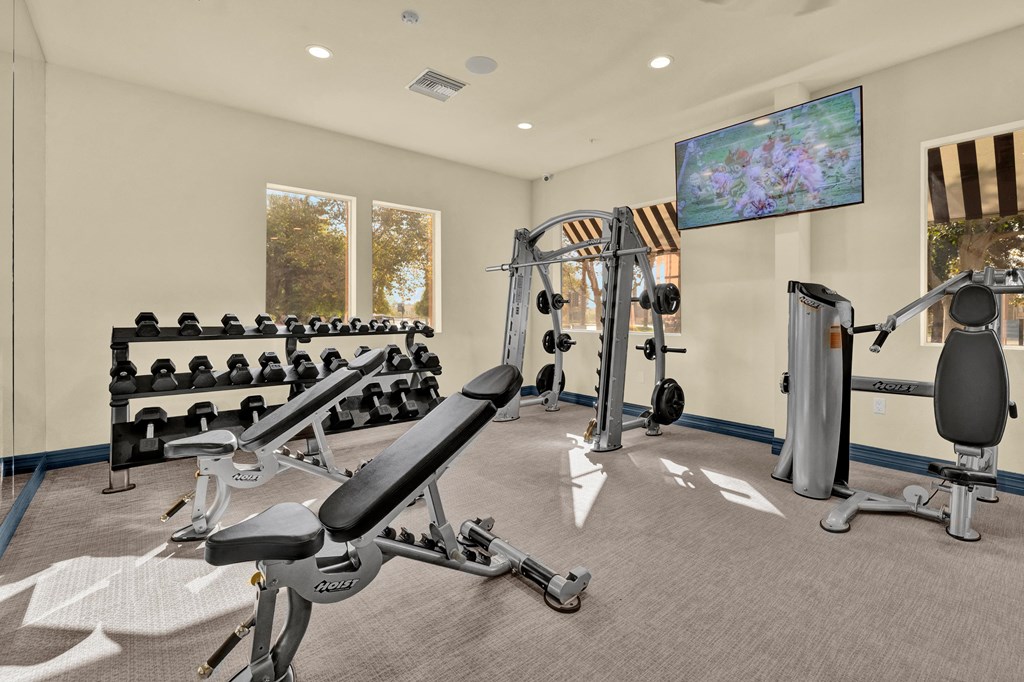 a gym with weights and cardio equipment at the enclave at