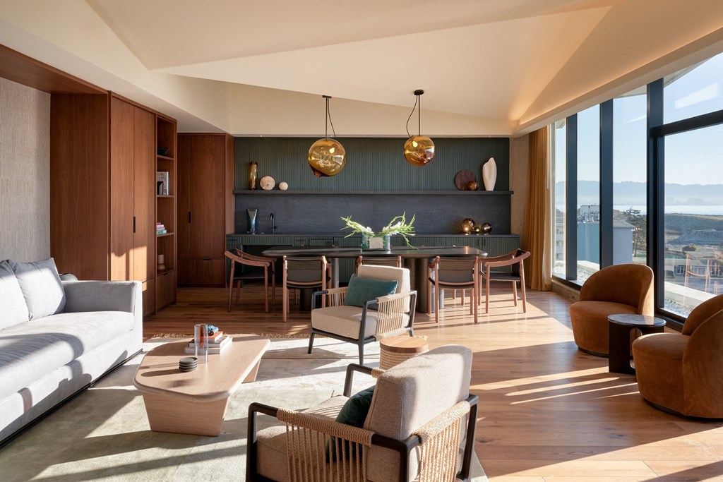 a living room with a white couch and a table with chairs and a large window