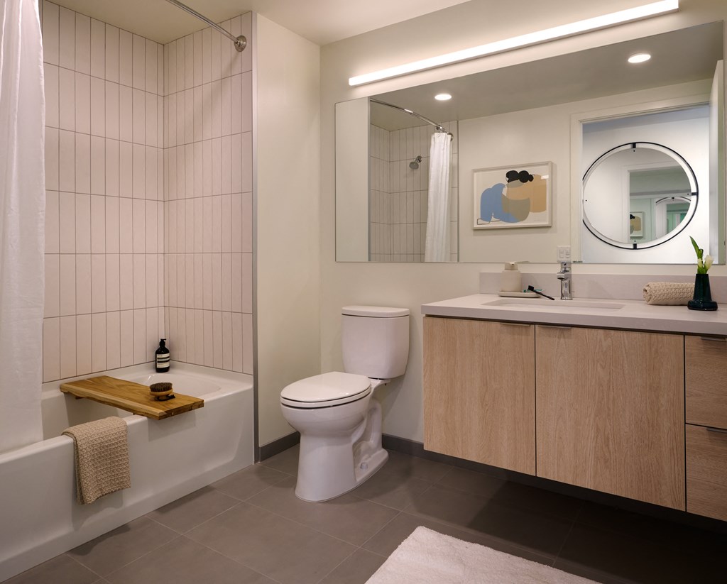a bathroom with a toilet sink and tub and a mirror