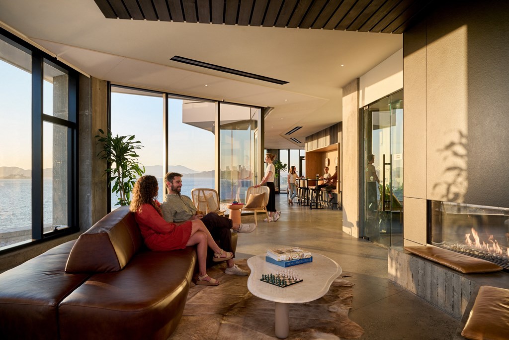 a man and a woman sitting in a living room with a fireplace