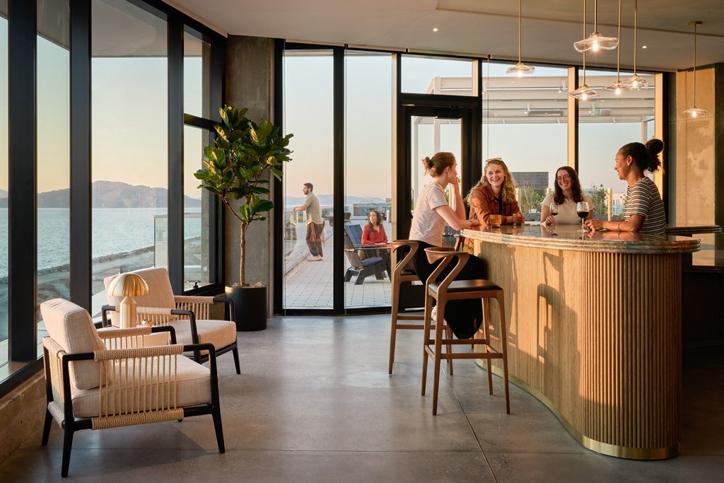 a group of people sitting at a bar with a view of the ocean and a
