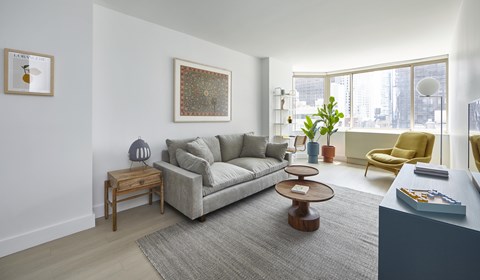 A living room with a grey couch, a yellow chair, and a coffee table.