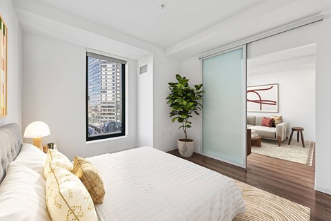 A bedroom with a large bed and a plant.