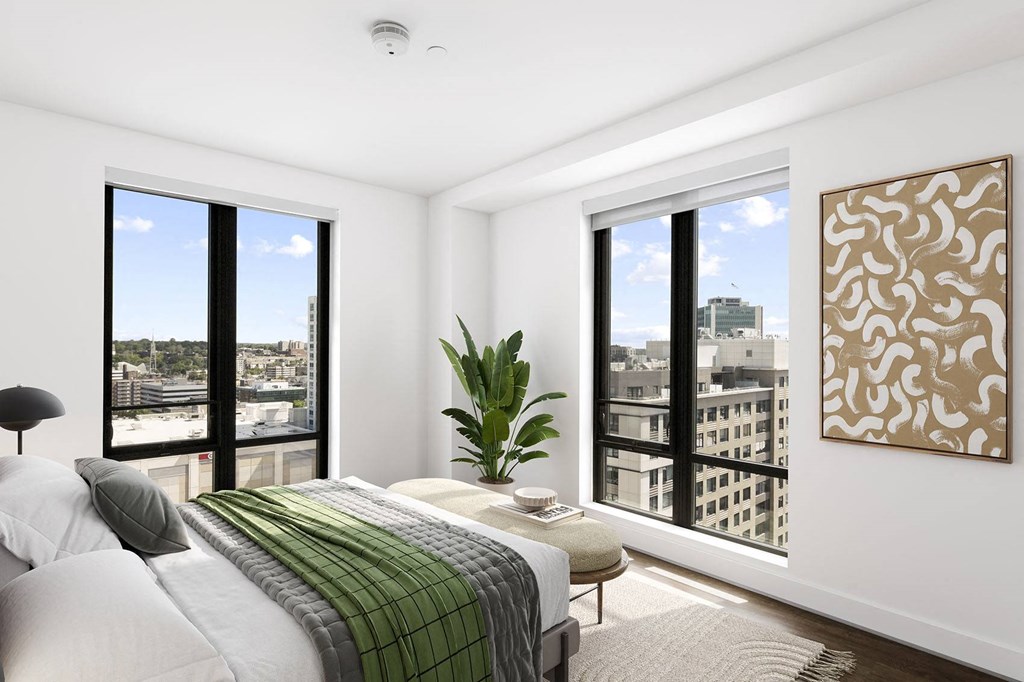 a bedroom with a large bed and two large windows