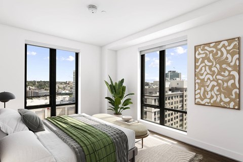 a bedroom with a large bed and two large windows