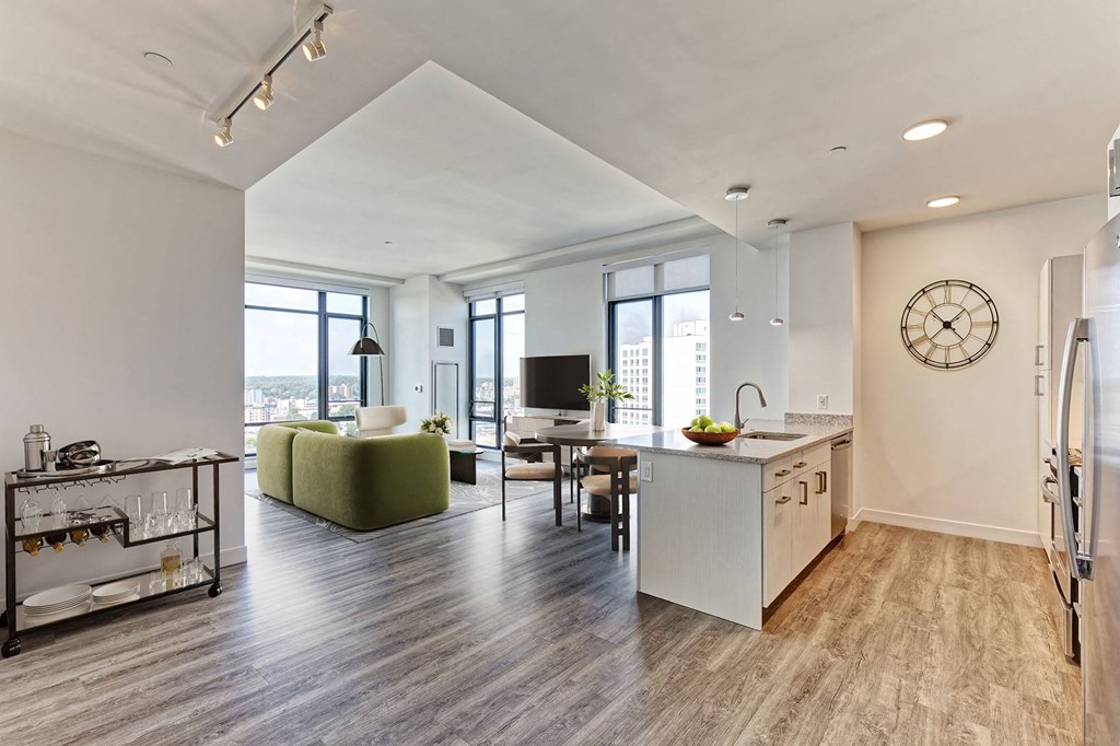 a kitchen and living room with a large clock on the wall