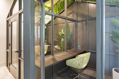 a desk with a chair in a room with glass doors