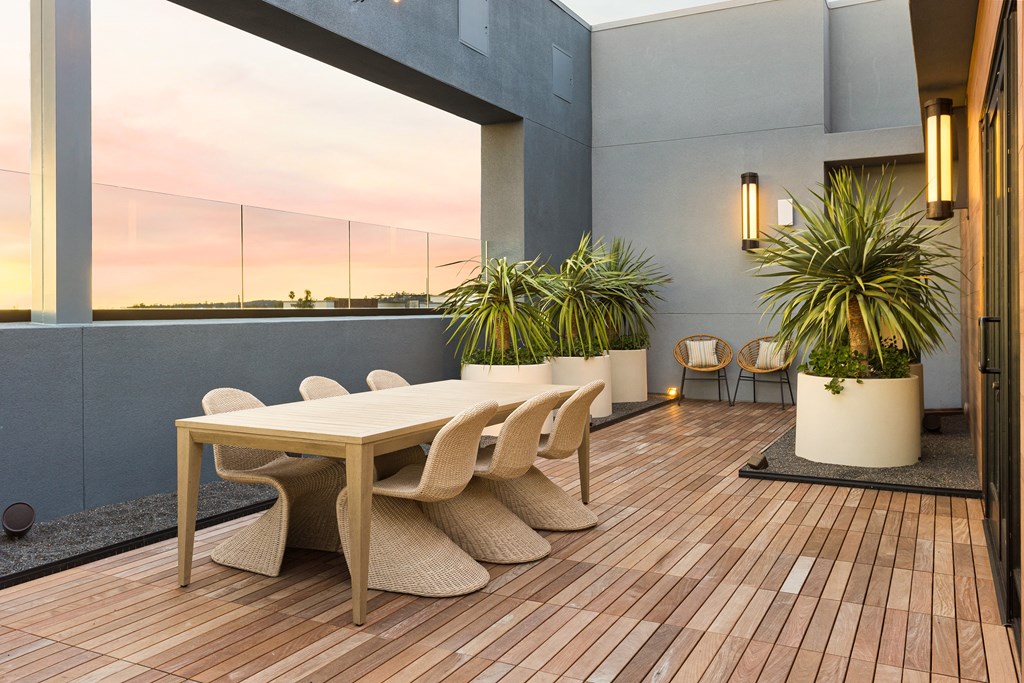 a dining area with a table and chairs on a balcony