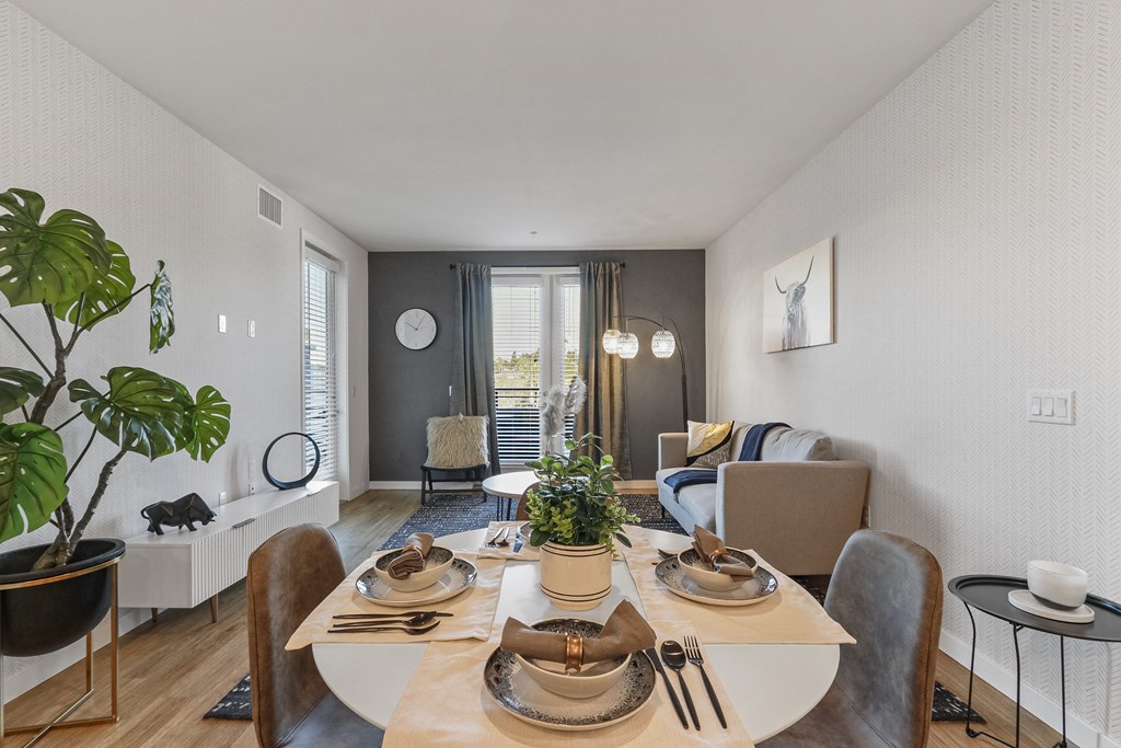 Dining area with a table and chairs and a living room with a couch and a window at Array La Mesa, La Mesa California