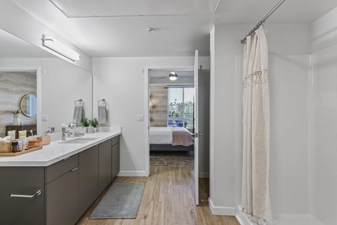 Bathroom with a shower and a bed in the background at Array La Mesa, La Mesa, CA