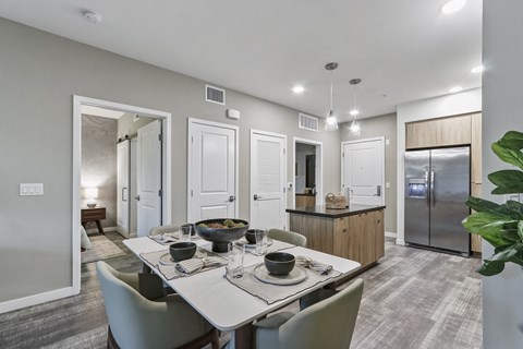 Dining area with a table and chairs and a kitchen in the background at Array La Mesa, California