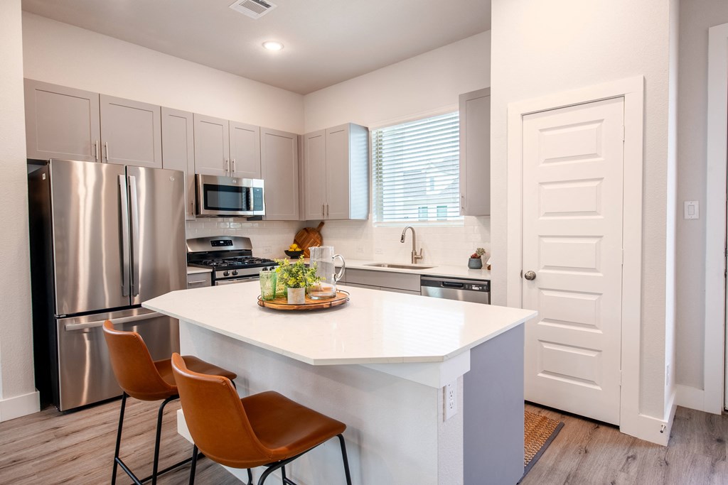 a kitchen with stainless steel appliances and a white counter top