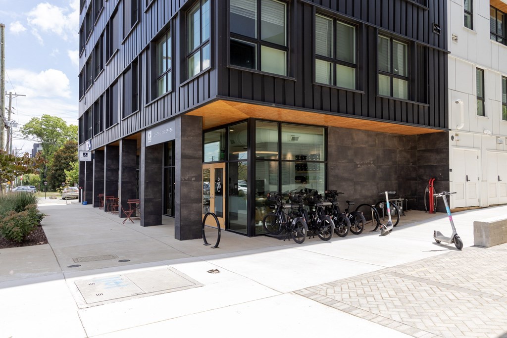 A modern building with a black facade and a row of bicycles parked in front.